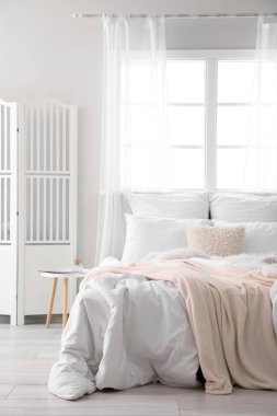 Büyük yataklı, masalı ve katlanır ekranlı aydınlatma odasının içi