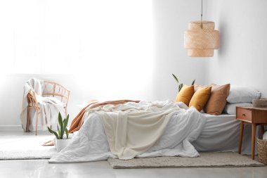 Büyük yataklı, masalı ve koltuklu modern bir oda.