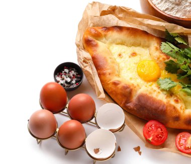 Lezzetli Ajarian khachapuri, beyaz arka planda yumurta ve baharatlar.