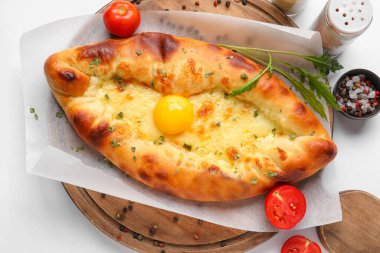 Beyaz arka planda lezzetli Ajarian Khachapuri tahtası, yakın plan.