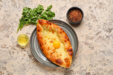 Lezzetli Ajarian Khachapuri tabağı, kişniş ve grunge arka planda baharatlar.