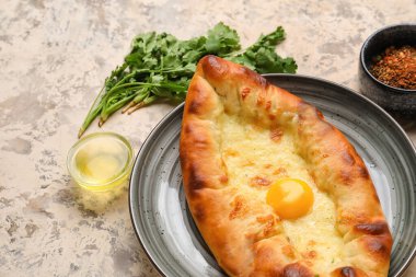 Lezzetli Ajarian Khachapuri tabağı, kişniş ve arkaplanda baharatlar, yakın plan.