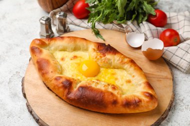 Hafif arka planda lezzetli Ajarian Khachapuri tahtasına yakın plan.