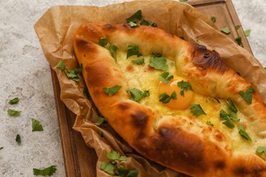 Hafif arka planda lezzetli Ajarian Khachapuri tahtasına yakın plan.