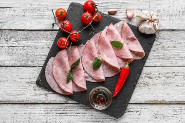 Lezzetli jambon, domates ve arkaplanda baharatlar.