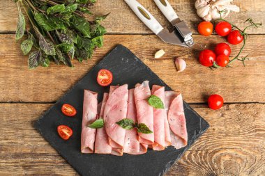 Lezzetli jambon, domates ve fesleğen dilimli tahta arka planda.