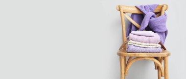 Tahta sandalyede örülmüş süveterler hafif arkaplan ve metin için yer var.