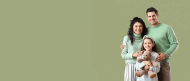 Renkli arka planda kalın kazaklar içinde mutlu bir aile ve metin için yer var