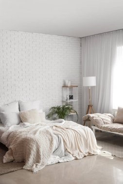 Yatak odasının içinde raf ünitesi ve lamba var.