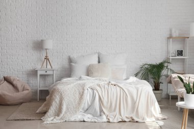 Masası, lambası ve raf ünitesi olan aydınlık yatak odasının içi