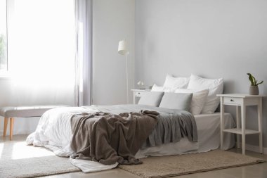 Büyük yataklı, masalı ve lambalı modern bir oda.