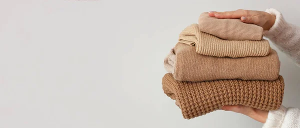 Dłonie Kobiety Stosem Beżowych Swetrów Jasnym Tle Miejscem Tekst — Zdjęcie stockowe
