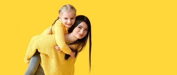 快乐的妈妈和她的小女儿穿着温暖的毛衣 背景是黄色的 有文字空间 — 图库照片