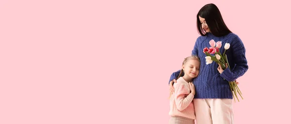 Happy Mother Flowers Her Little Daughter Warm Sweaters Pink Background — Stock Photo, Image