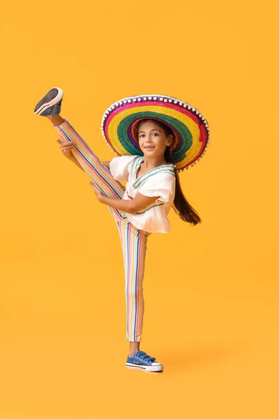 幸せな小さなメキシコの女の子でカラフルなSombrero帽子上の黄色の背景 — ストック写真