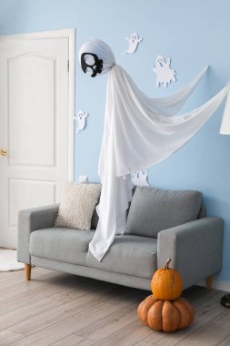 Kanepesi ve Cadılar Bayramı dekoru olan şık bir oturma odası.