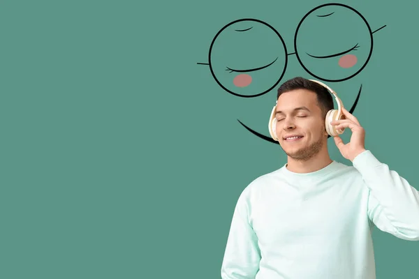 Junger Mann Mit Kopfhörern Und Gezeichnetem Lächeln Auf Grünem Hintergrund — Stockfoto