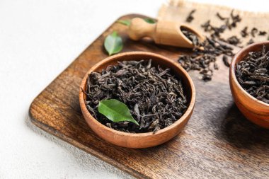 Beyaz arka planda kuru çay yapraklı kase