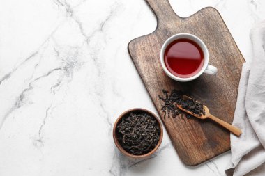 Kuru çay yapraklı kompozisyon ve mermer arka planda sıcak içecek.