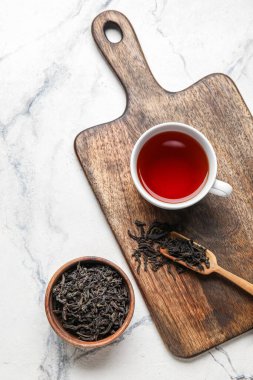 Kuru çay yapraklı kompozisyon ve mermer arka planda sıcak içecek.