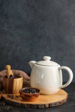 Kuru çay yapraklı kompozisyon ve koyu arkaplanda sıcak içecek.