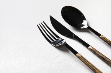 Çatal, bıçak ve kaşık beyaz arka planda, yakın plan.