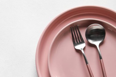 Plakalar, kaşıklar ve çatallar beyaz arka planda, yakın plan