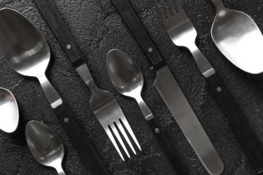 Koyu arkaplanda farklı çatal bıçak takımı, üst görünüm