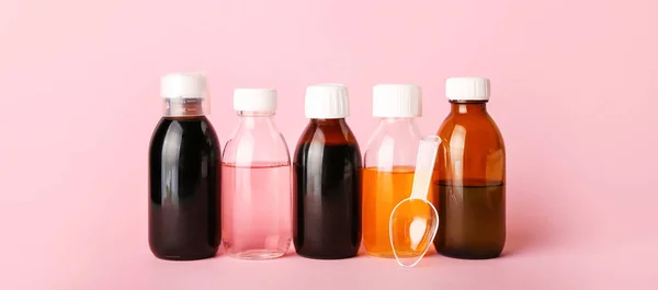 Bottles of cough syrup on pink background