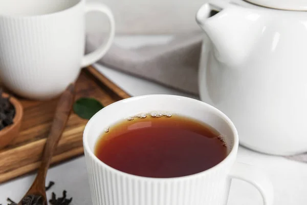 Cup of hot black tea on table, closeup