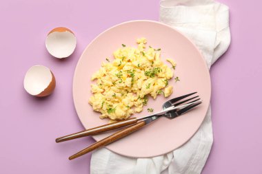 Lezzetli çırpılmış yumurta tabağı ve leylak arka planda kabuklar.