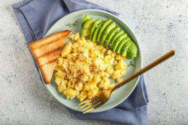 Yağda yumurta, avokado ve açık arkaplanda tost.