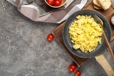 Arkaplanda çırpılmış yumurta olan ahşap tahta bir tava.