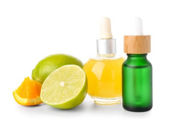 Beyaz arka planda narenciye meyveli bir şişe serum.