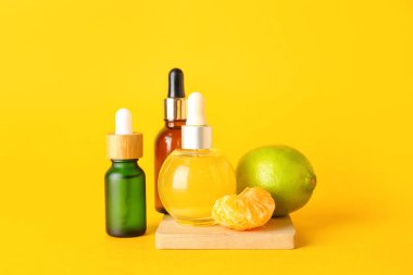 Sarı arka planda narenciye serumu şişeleri