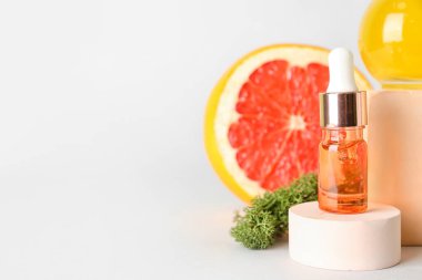 Gri zemin üzerinde narenciye serumu olan şişe