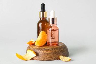 Gri zemin üzerinde narenciye serumu olan şişeler.