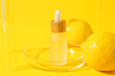 Sarı zemin üzerinde bir şişe C vitamini serumu