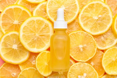 Limon dilimlerinde bir şişe C vitamini serumu.