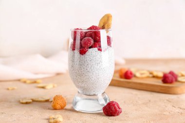 Lezzetli chia tohumu pudingi ve olgun ahududu ile dolu bir bardak.