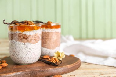 Ahşap masada reçelli Chia tohumu pudingi.