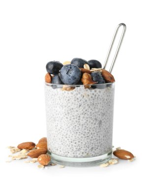 Beyaz arka planda böğürtlen ve fındıklı bir bardak Chia tohumu pudingi.