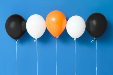 Cadılar Bayramı balonları mavi duvarın yanında