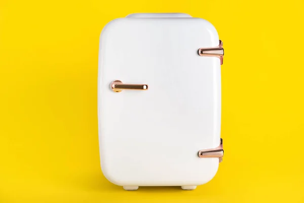Small cosmetic refrigerator on yellow background