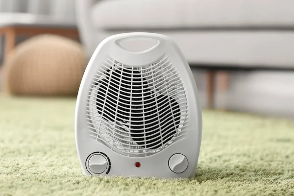 Electric fan heater on carpet in living room