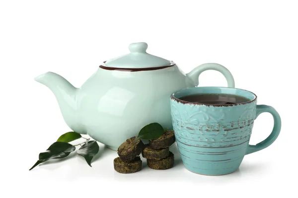 Dry pressed puer tea with leaves, cup and teapot on white background