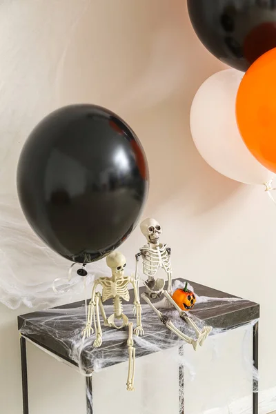 Stół Szkieletami Dynia Halloween Balony Pobliżu Ściany Światła — Zdjęcie stockowe