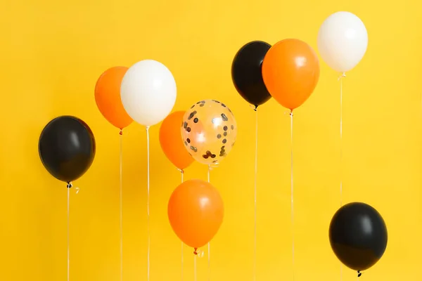 Halloween balloons on yellow background