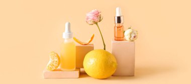 İçinde yağ şişeleri, gül çiçekleri ve turunçgiller olan bej arka planda kompozisyon