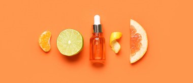 Turuncu arka planda turunçgil yağı ve meyveli kompozisyon